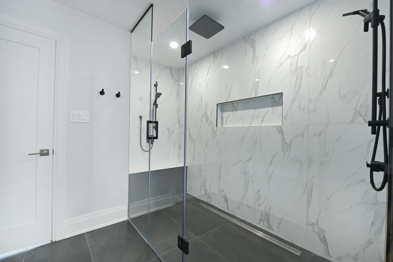 Contemporary marble walk-in shower with glass enclosure and layered lighting